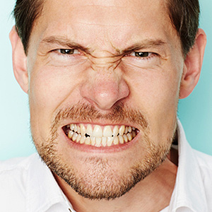 Skopek Orthodontics man aggressively grinding his teeth